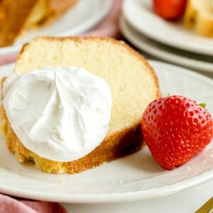 A closer look on slice of Paula Deen Pound Cake with frosting on top and strawberry on side.