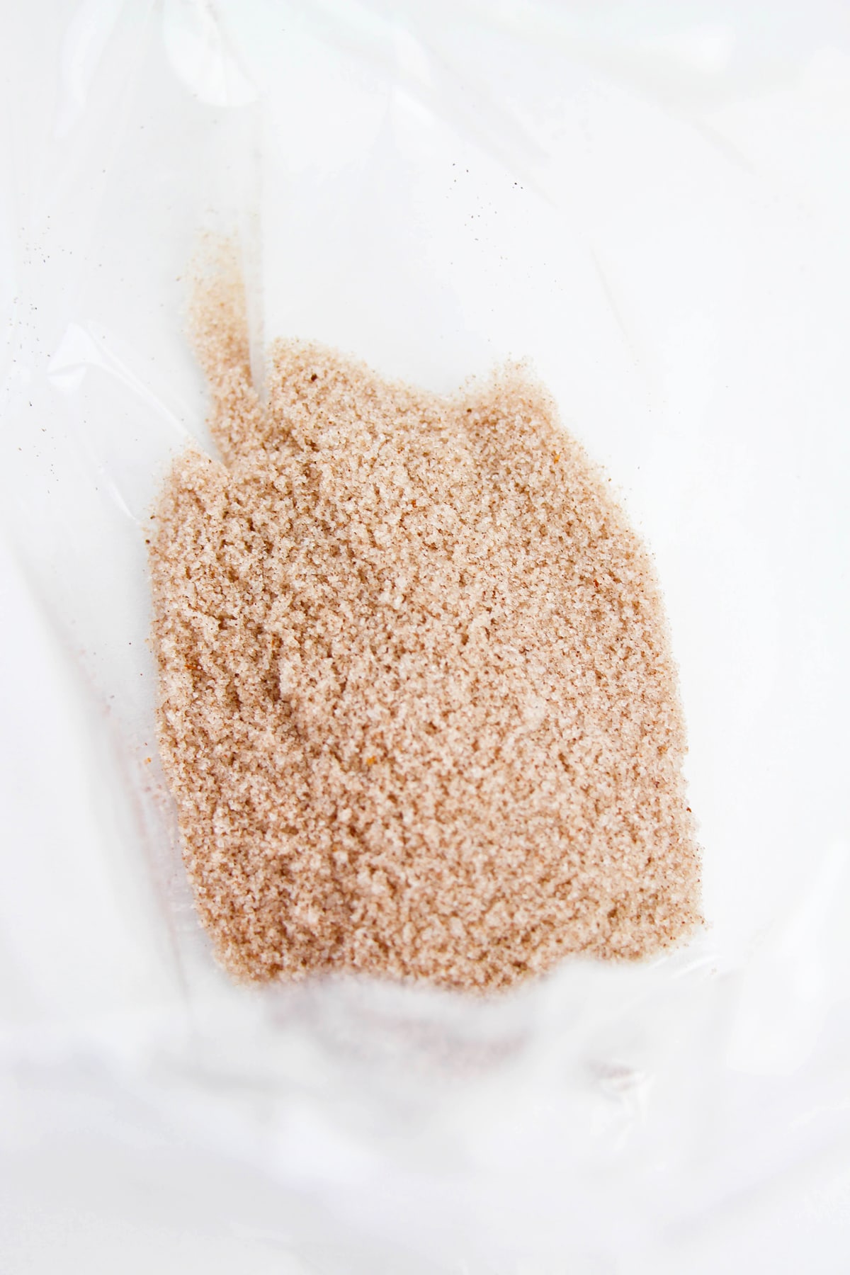 A close-up view of a mixture of cinnamon and sugar for Churro Muddy Buddies recipe.