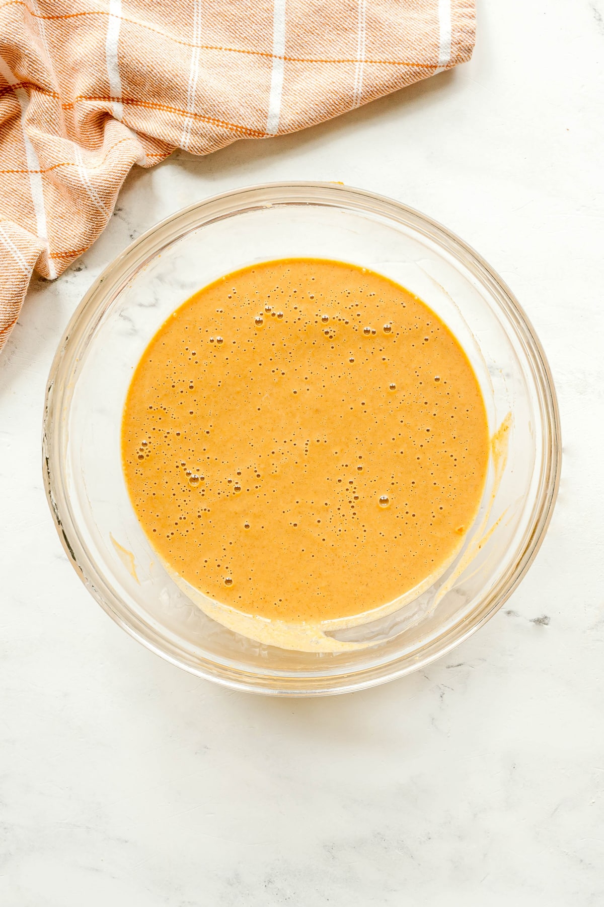 Next step in preparing Mini Pumpkin Pies is to whisk together pumpkin puree, sweetened condensed milk, eggs, pumpkin pie spice, and vanilla extract until smooth.