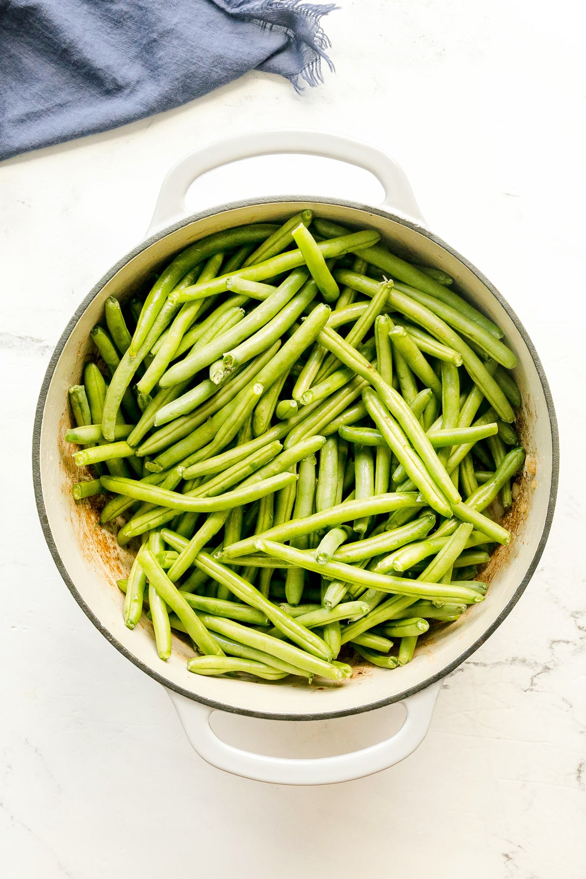 Adding fresh green beans to the sauteed onion. This is one step in preparing Southern Green Beans recipe.