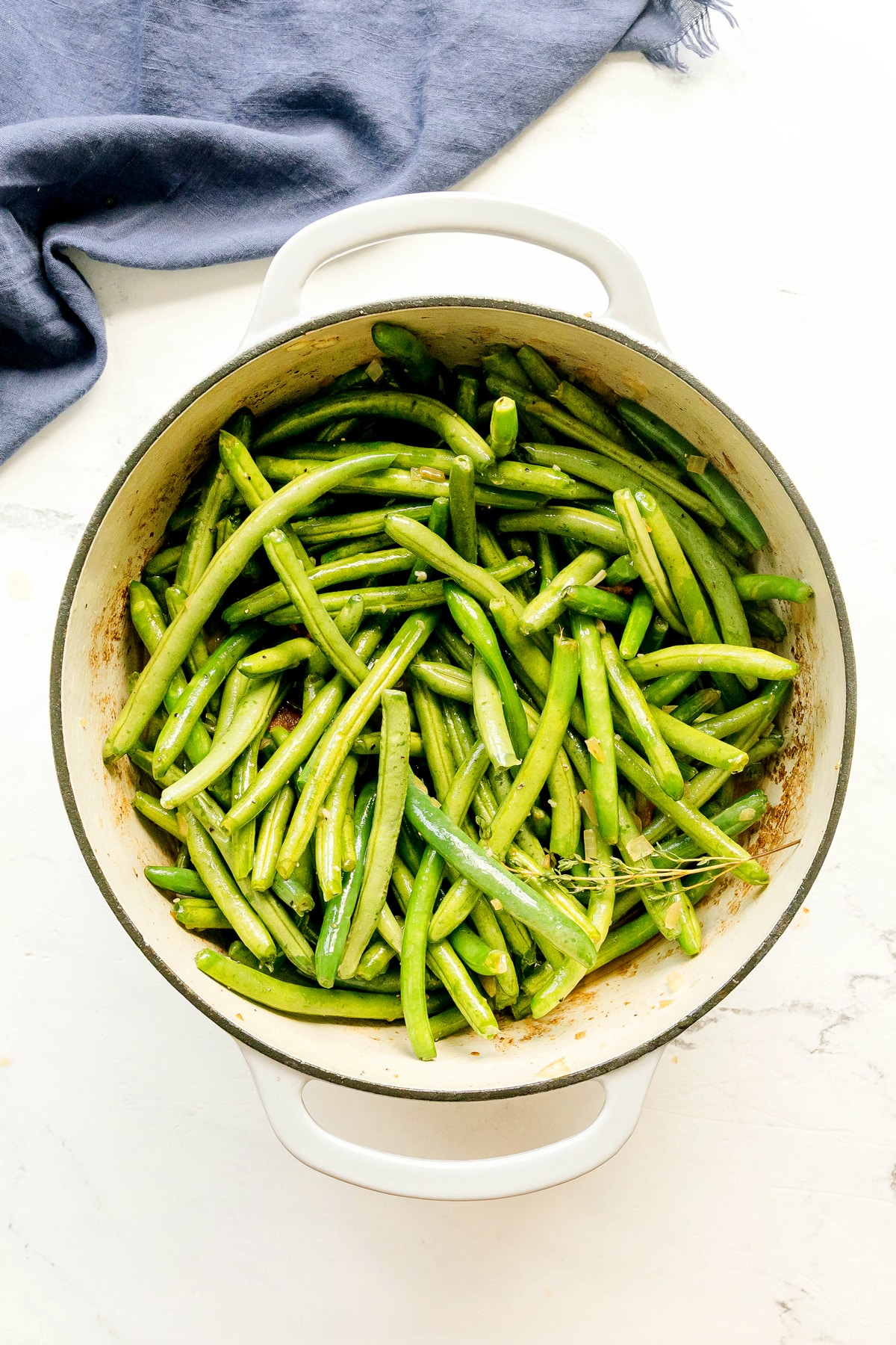 Next step in preparing Southern Green Beans is to add chicken stock, thyme, salt, and black pepper to the green beans.